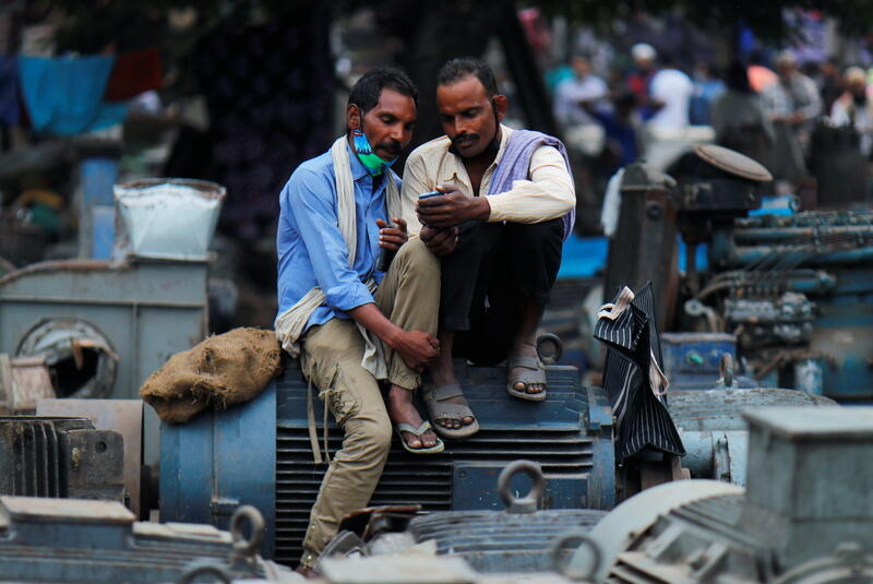 Men look at a mobile phone in Delhi, India, November 2020. REUTERS/Adnan Abidi