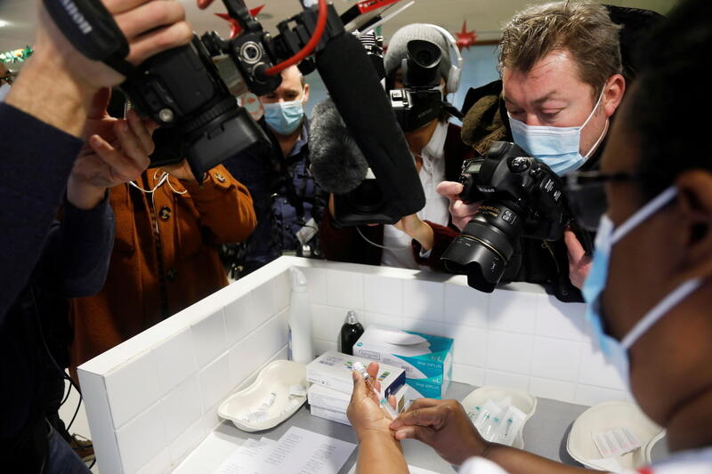 A nurse prepares a dose of the Pfizer-BioNTech COVID-19 vaccine, surrounded by media staff, Bobigny, France, December 30, 2020. REUTERS/Charles Platiau