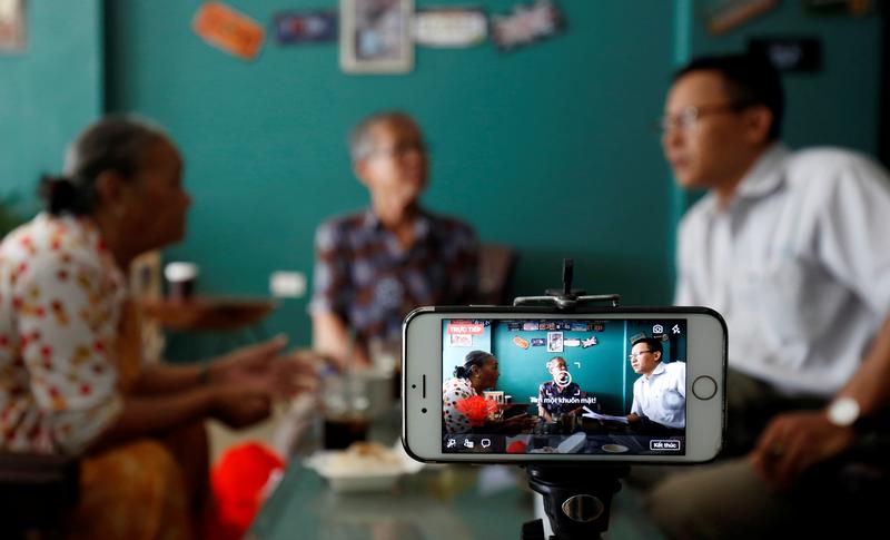 Rights activist Le Van Dung (R) live streams on Facebook in a coffee shop in Hanoi, Vietnam May 15, 2018. Picture taken May 15, 2018. REUTERS/Kham