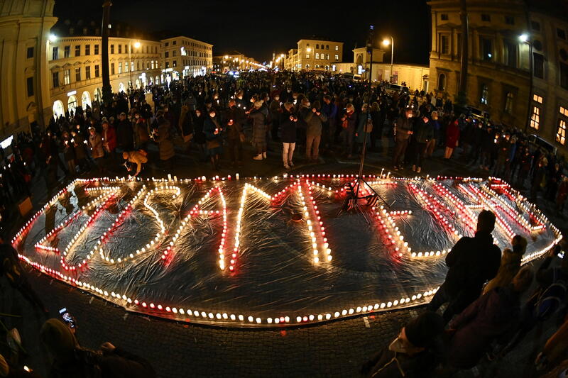 People light candles in the shape of a sign which reads "Solidarity" in protest against coronavirus disease (COVID-19) deniers at Odeonsplatz in Munich, Germany February 10, 2022. Picture taken with a a fish-eye lens. REUTERS/Lukas Barth