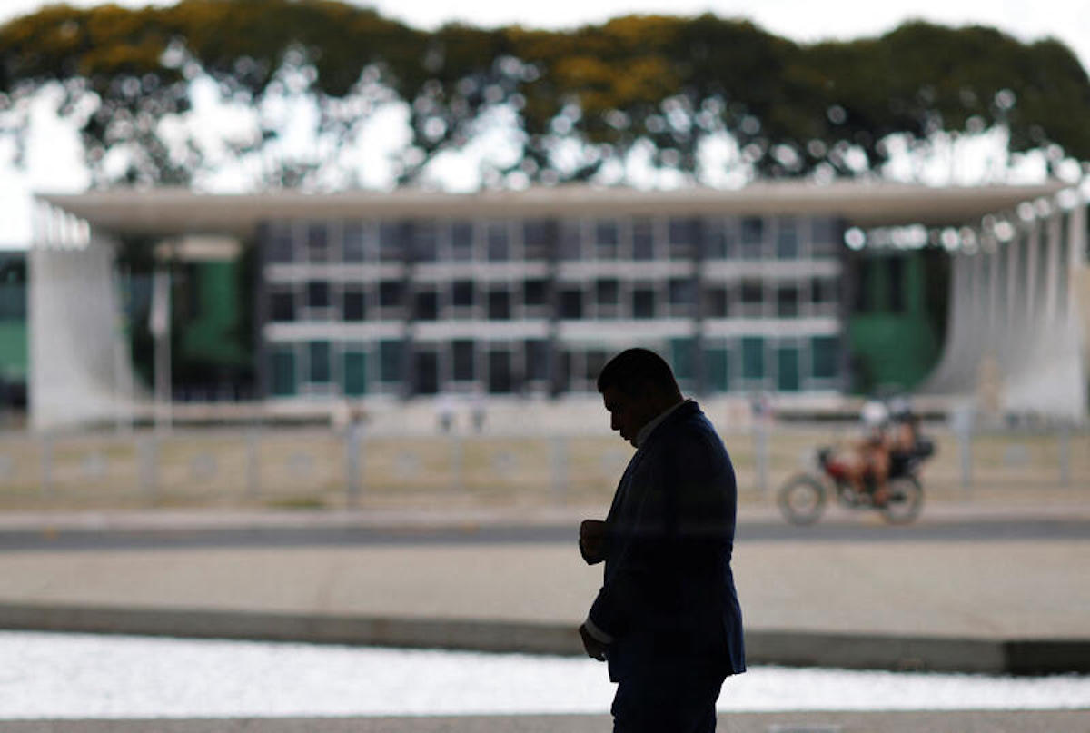 A man walks at the Planalto Palace, with the headquarters of the supreme court in the background, almost one year after the protest of January 8 with the supporters of Brazil's former President Jair Bolsonaro against President Luiz Inacio Lula da Silva, in Brasilia, Brazil December 27, 2023. REUTERS/Adriano Machado