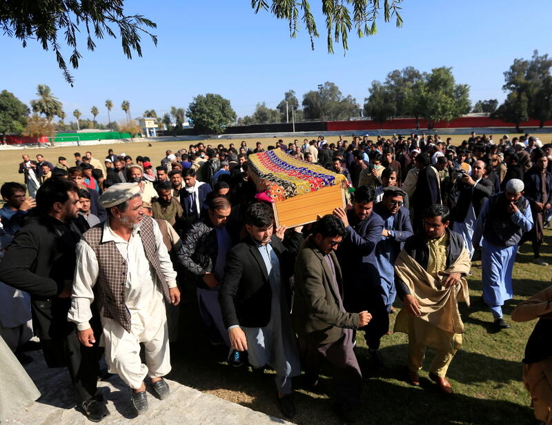 Afghan men carry the coffin of journalist Malalai Maiwand, who was shot and killed by unknown gunmen in Jalalabad, Afghanistan December 10, 2020. REUTERS/Parwiz