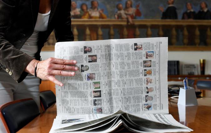Journalist Daniela Taiocchi leafs through an edition of the newspaper L'Eco di Bergamo in which ten pages of obituaries have been published due to the high number of deaths from the coronavirus disease (COVID-19), in Bergamo, Italy May 12, 2020. Picture taken May 12, 2020. REUTERS/Flavio Lo Scalzo