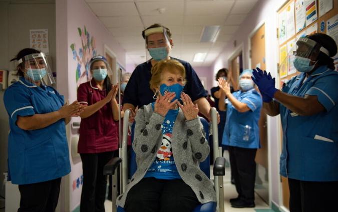 Margaret Keenan, 90, is applauded by staff as she returns to her ward after becoming the first person in Britain to receive the Pfizer/BioNTech COVID-19 vaccine at University Hospital, at the start of the largest ever immunisation programme in the British history, in Coventry, Britain December 8, 2020. Britain is the first country in the world to start vaccinating people with the Pfizer/BioNTech jab. Jacob King/Pool via REUTERS