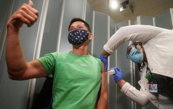Dr. Tommy Wong gives a thumbs up as he receives one of the first vaccinations at Mt. Sinai Hospital from Pfizer-BioNTech during the coronavirus disease (COVID-19) pandemic in the Manhattan borough of New York City, New York, U.S., December 15, 2020. REUTERS/Carlo Allegri