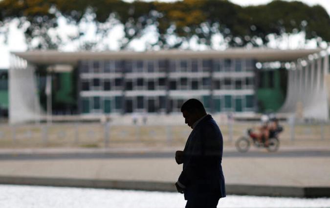 A man walks at the Planalto Palace, with the headquarters of the supreme court in the background, almost one year after the protest of January 8 with the supporters of Brazil's former President Jair Bolsonaro against President Luiz Inacio Lula da Silva, in Brasilia, Brazil December 27, 2023. REUTERS/Adriano Machado