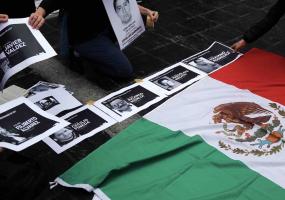 People place photos of murdered journalists next to the national Mexican flag in Buenos Aires. Reuters/Marcos Brindicci