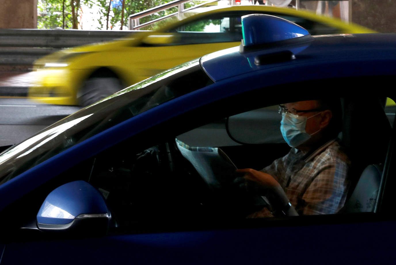man reads newspaper in taxi