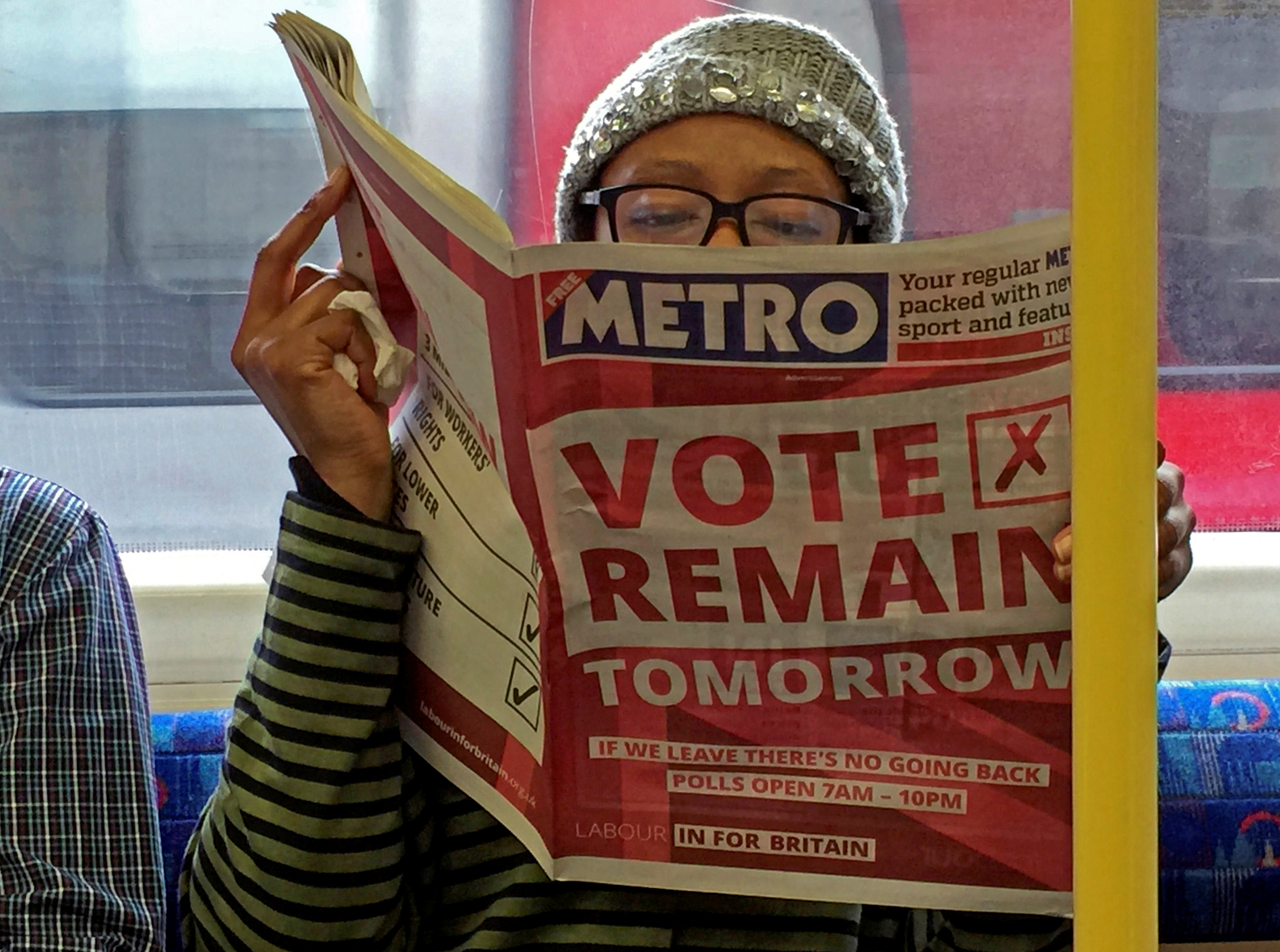 A woman reads a newspaper in London during the EU referendum campaign