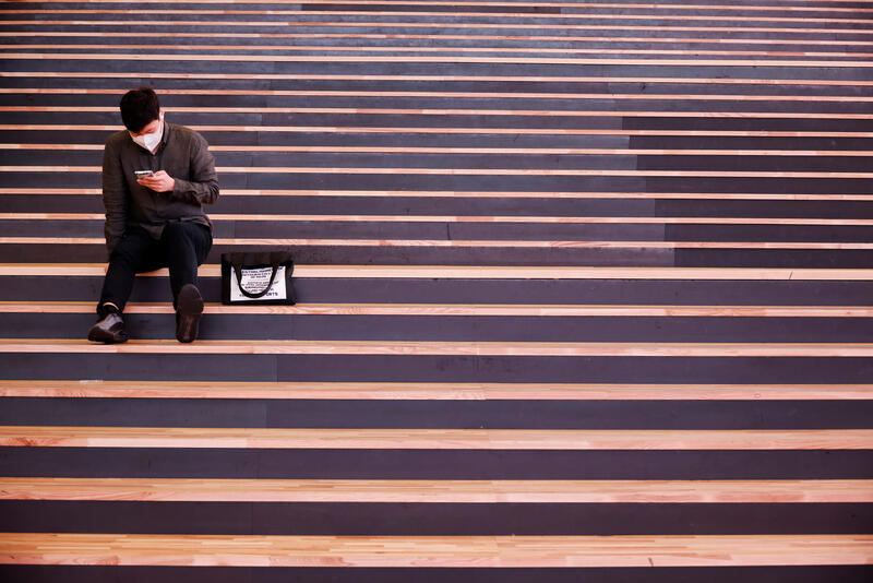 Man sits looking at mobile phone (REUTERS/Kim Hong-Ji)