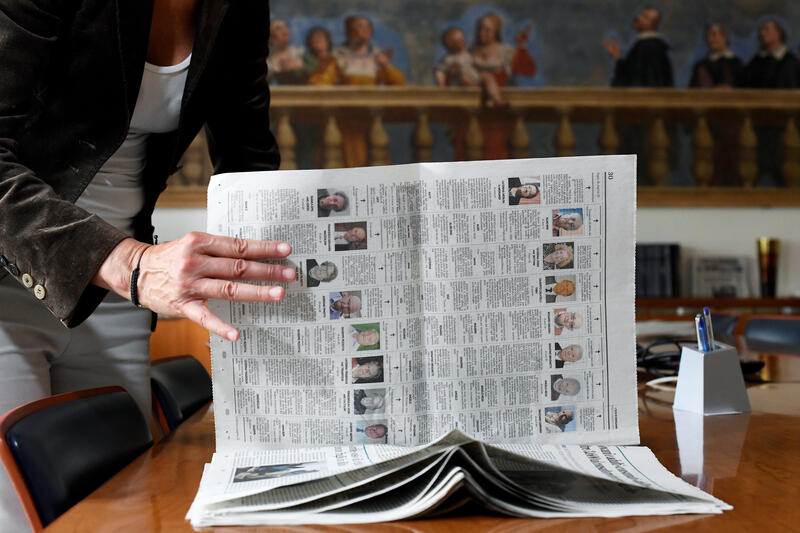 Journalist Daniela Taiocchi leafs through an edition of the newspaper L'Eco di Bergamo in which ten pages of obituaries have been published due to the high number of deaths from the coronavirus disease (COVID-19), in Bergamo, Italy May 12, 2020. Picture taken May 12, 2020. REUTERS/Flavio Lo Scalzo