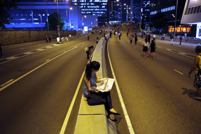 A pro-democracy protester reads a newspaper, Hong Kong. REUTERS/Carlos Barria