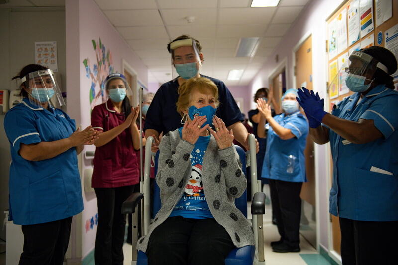 Margaret Keenan, 90, is applauded by staff as she returns to her ward after becoming the first person in Britain to receive the Pfizer/BioNTech COVID-19 vaccine at University Hospital, at the start of the largest ever immunisation programme in the British history, in Coventry, Britain December 8, 2020. Britain is the first country in the world to start vaccinating people with the Pfizer/BioNTech jab. Jacob King/Pool via REUTERS