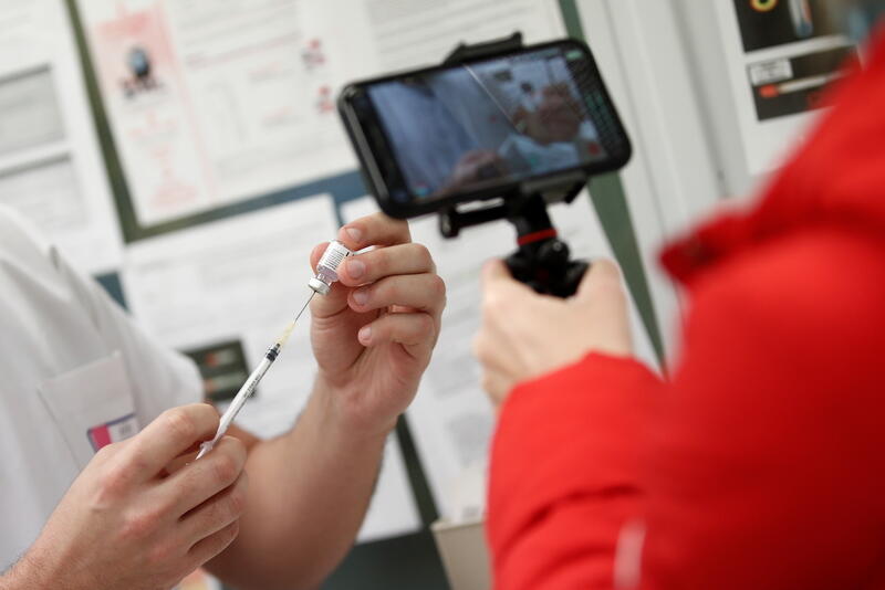 A journalist films with her mobile phone a medical worker drawing the Pfizer-BioNTech Covid-19 vaccine from a vial at the Max Fourastier hospital in Nanterre, as the spread of the coronavirus disease (COVID-19) continues in France, January 5, 2021. REUTERS/Benoit Tessier