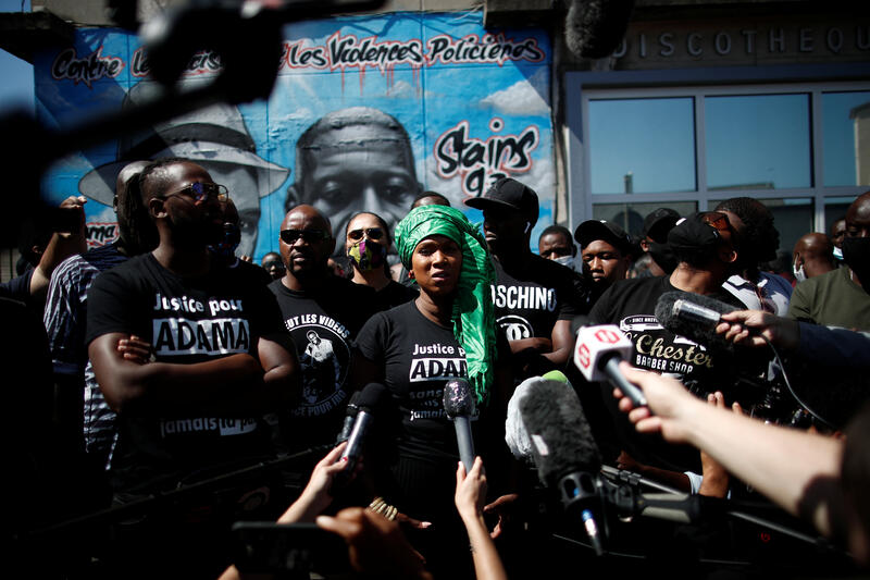 Assa Traore, sister of Adama Traore, a 24-year-old Black Frenchman who died in a 2016 police operation, talks to journalists during a gathering in front of a fresco in memory of Adama Traore and George Floyd, whose death in police custody has sparked unrest in the United States, with the slogan "against racism and police violence" painted on a wall by a group of artists "Collectif Art" in Stains, France, June 22, 2020. REUTERS/Benoit Tessier