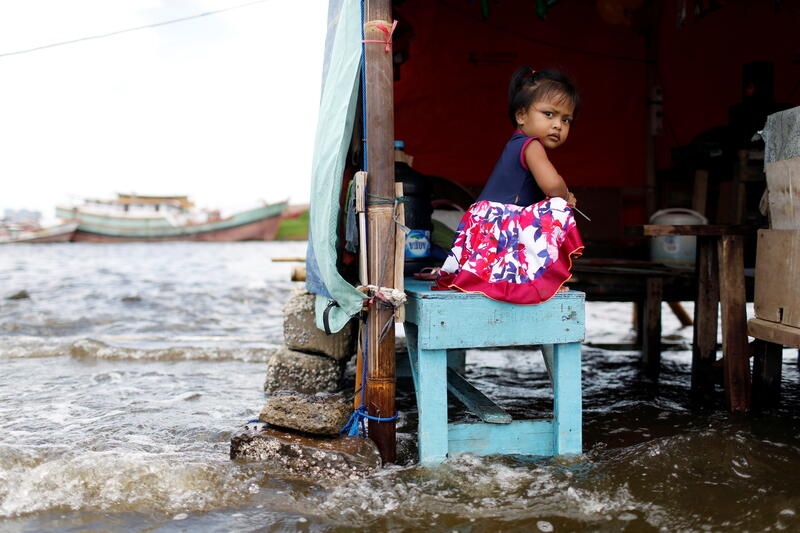 Shaqueena Dwi Arsyilla, 2, sits on a bench at Kali Adem port, which is impacted by high tides due to the rising sea level and land subsidence, north of Jakarta, Indonesia November 20, 2020. REUTERS/Willy Kurniawan