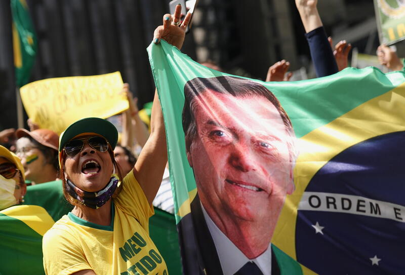 A supporter of President Jair Bolsonaro holds a banner with his image. REUTERS/Amanda Perobelli