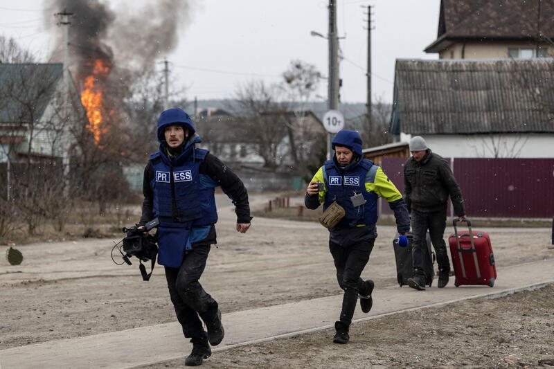 Journalists run for cover after heavy shelling on the only escape route used by locals, while Russian troops advance towards the capital, in Irpin, near Kyiv, Ukraine March 6, 2022. REUTERS/Carlos Barria
