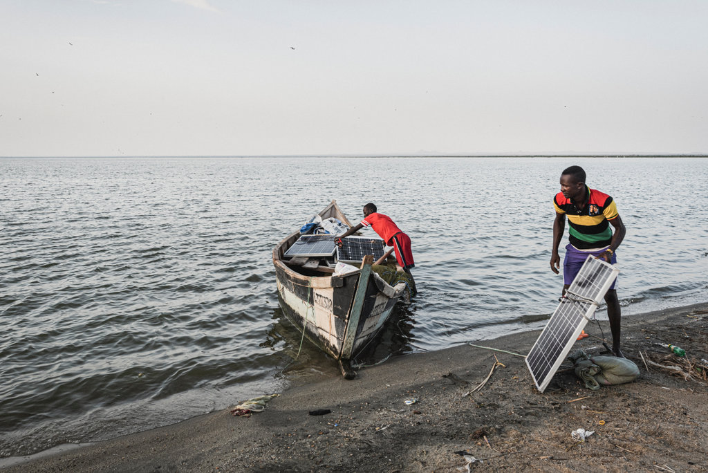 Two men load solar panels on a boat in Turkana County, Kenya. Credit: Maurizio Di Pietro / Climate Visuals Countdown