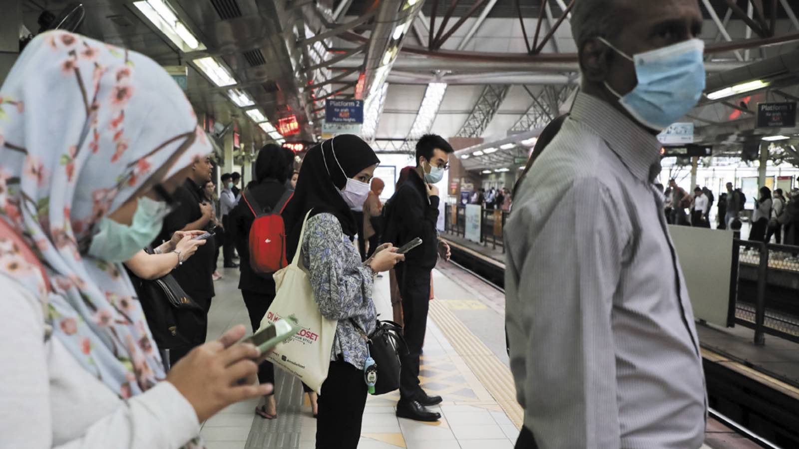 Passengers wear protective masks while they wait for Light Rail Transit train at a station, following the outbreak of the new coronavirus in China, in Kuala Lumpur, Malaysia, February 10, 2020. REUTERS/Lim Huey Teng