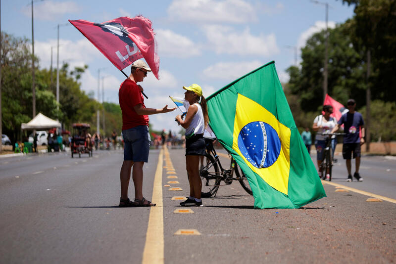 A supporter of Brazil's President and candidate for re-election Jair Bolsonaro talks with a supporter of Brazil's former President and presidential candidate Luiz Inacio Lula da Silva during an election campaign in Brasilia, Brazil October 16, 2022. REUTERS/Adriano Machado