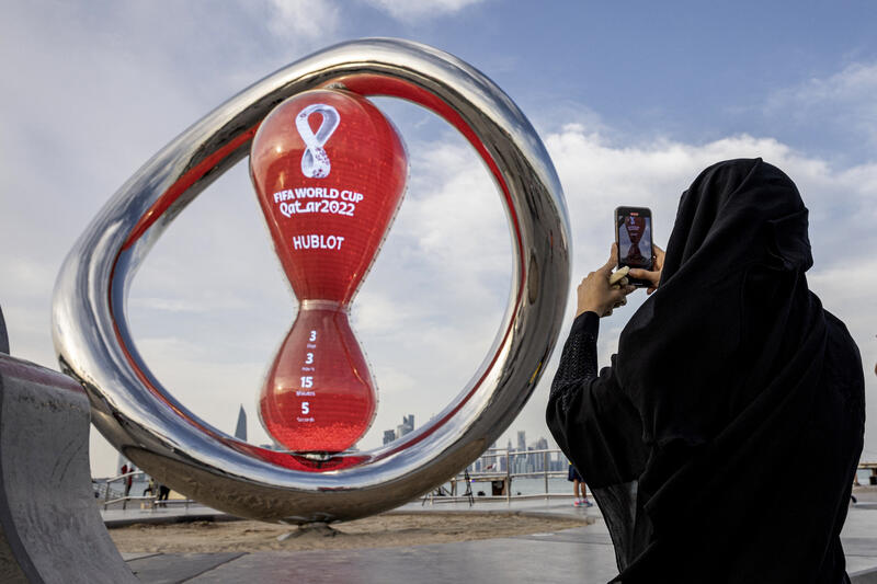 A fan takes a photograph of a countdown clock to the start of the World Cup. REUTERS/Marko Djurica