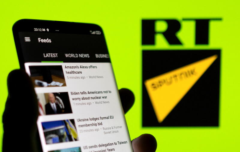 RT app is seen on a smartphone in front of RT and Sputnik logo in this illustration taken February 28, 2022. REUTERS/Dado Ruvic/Illustration