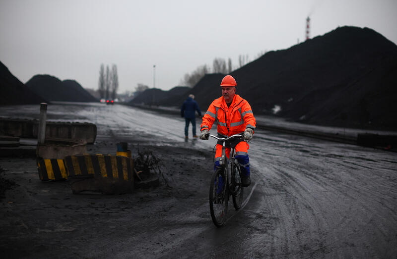 Image of man riding bicylce at a coal storage area in Gdansk