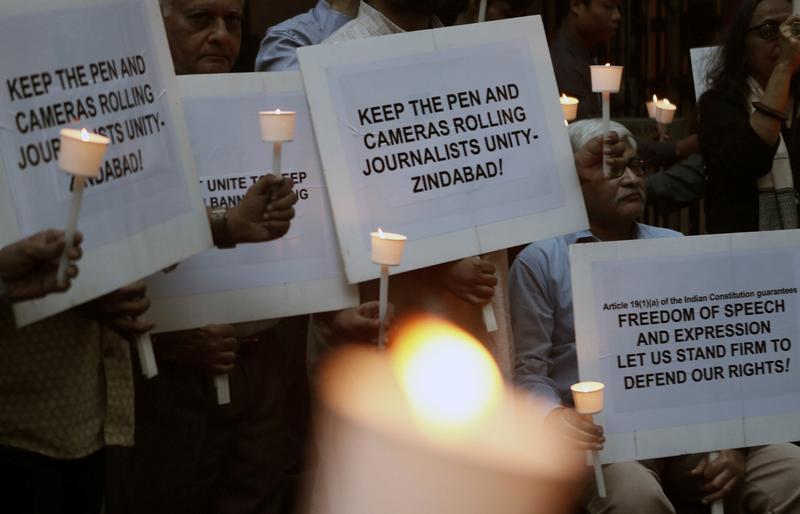 Journalists hold candles and placards during a vigil against police brutalities and attacks on press freedom in Mumbai in 2019. REUTERS/Francis Mascarenhas