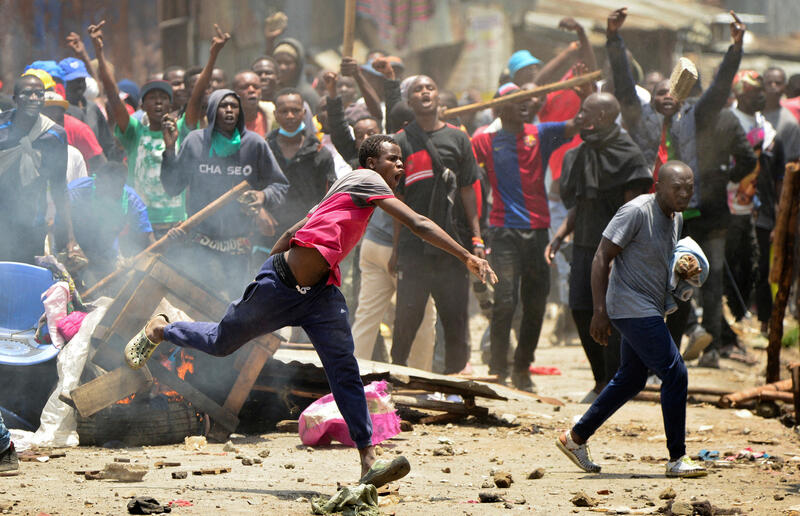 Supporters of Kenya's opposition leader Raila Odinga throw stones at riot police officers in Nairobi in March 2023. REUTERS/John Muchucha