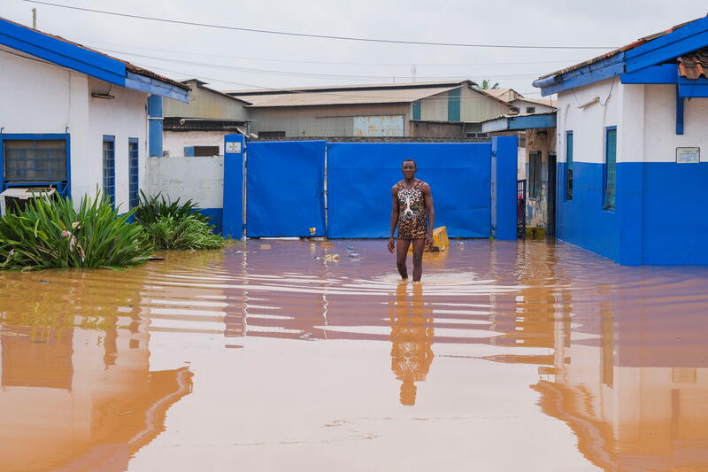 Boateng, a security guard, wades through flood waters after heavy rains in Accra. 