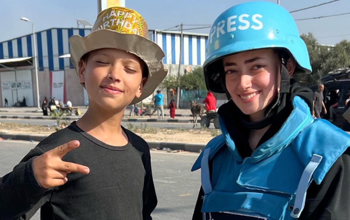 Plestia Alaqad poses with a boy she met offering biscuits to displaced people in Gaza. | Plestia Alaqad's Instagram