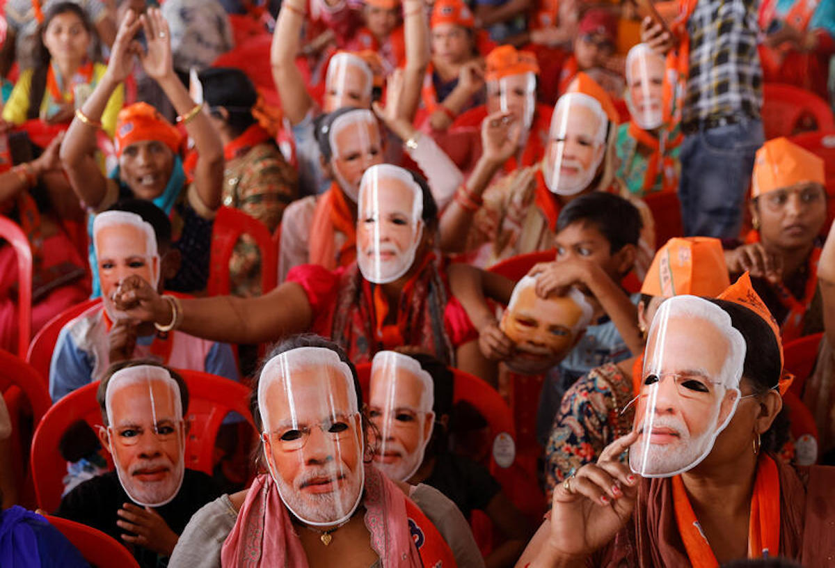Supporters of India's Prime Minister Narendra Modi wear masks of his face, as they attend an election campaign rally in Meerut, India, March 31, 2024. REUTERS/Anushree Fadnavis