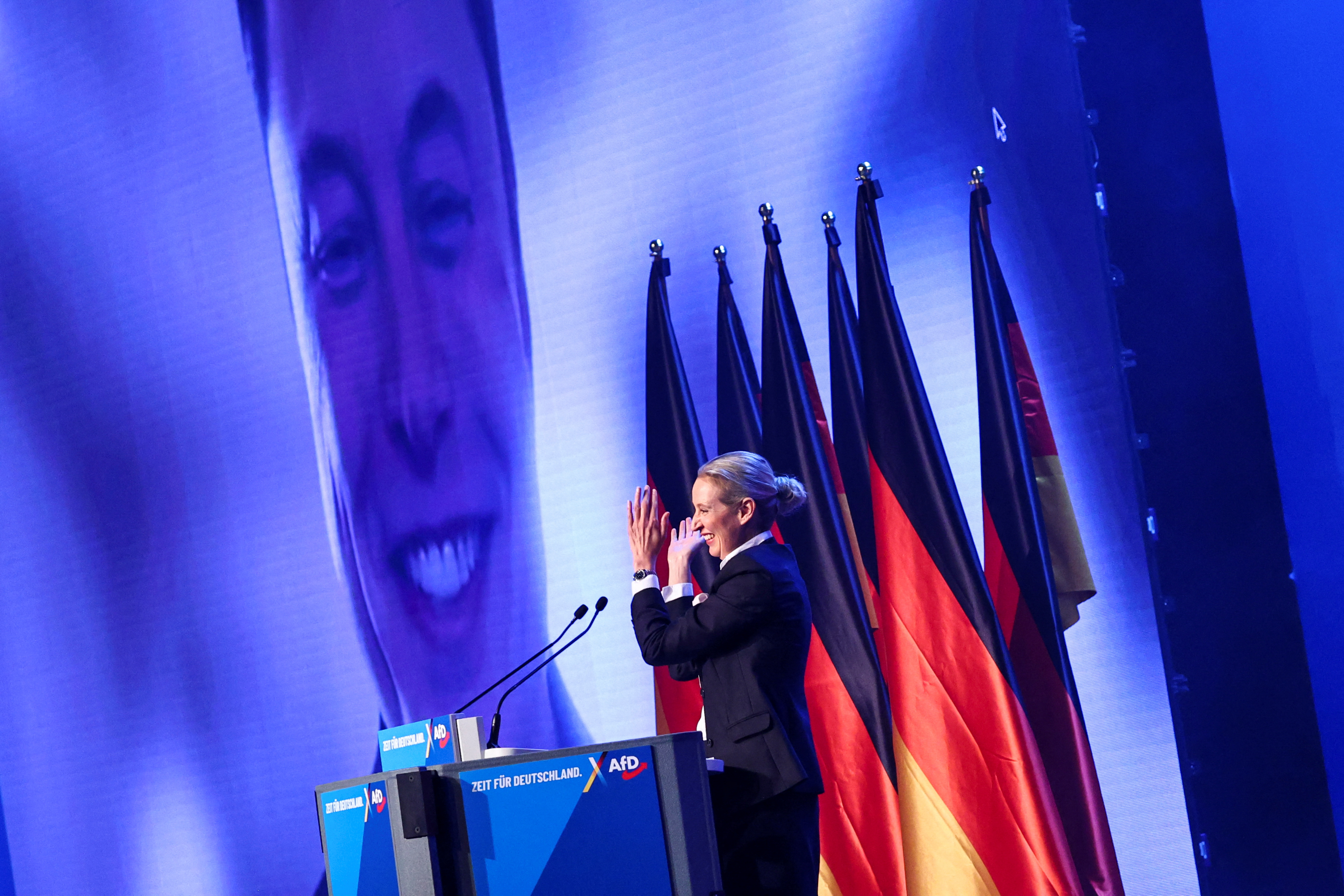 Alice Weidel, co-leader of the Alternative for Germany party (AfD), gestures as SpaceX CEO Elon Musk appears on screen during a central election campaign event of the AfD