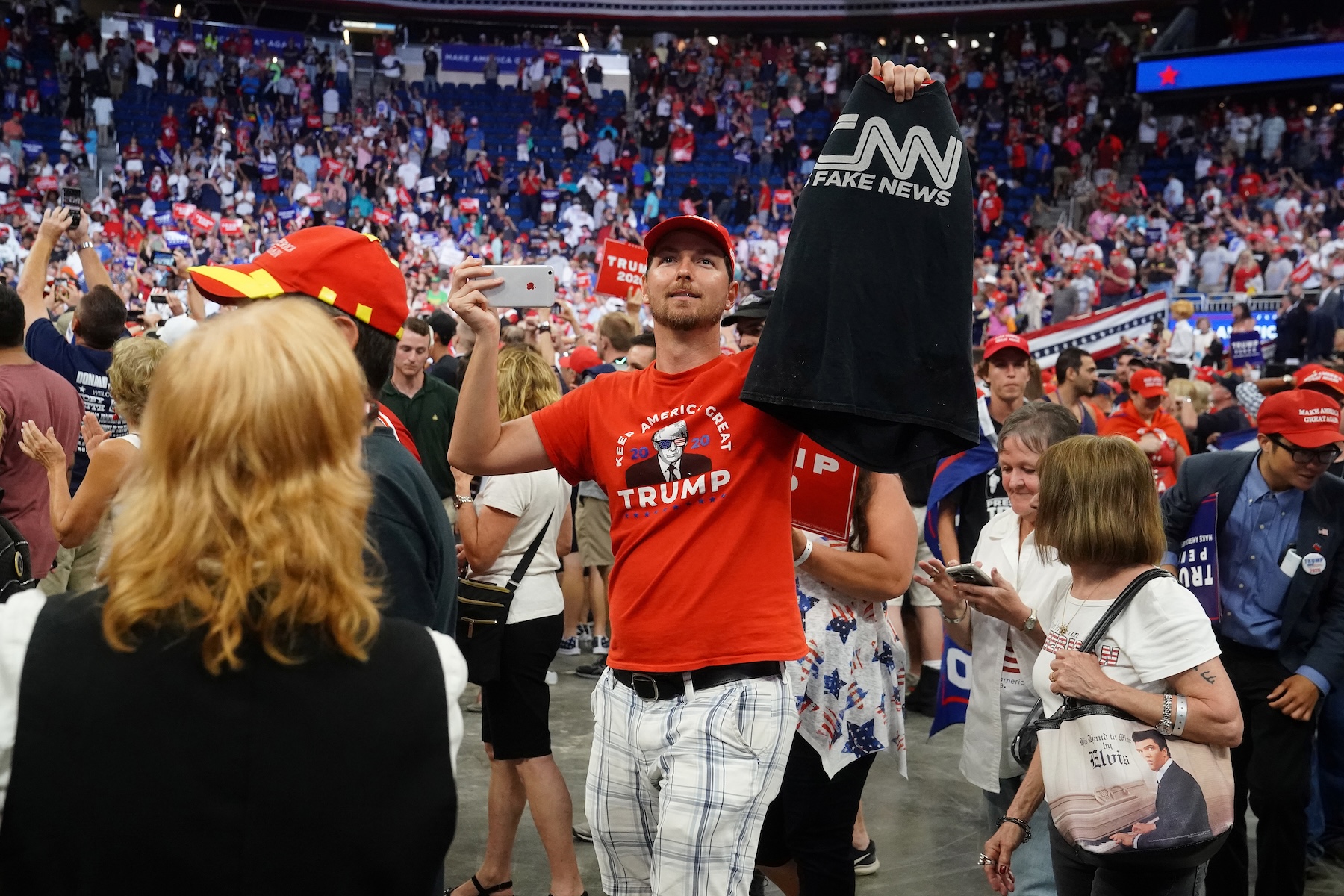 A man carries a 'Fake News' T-shirt at a campaign rally in Orlando, Florida in June 2019. REUTERS/Carlo Allegri