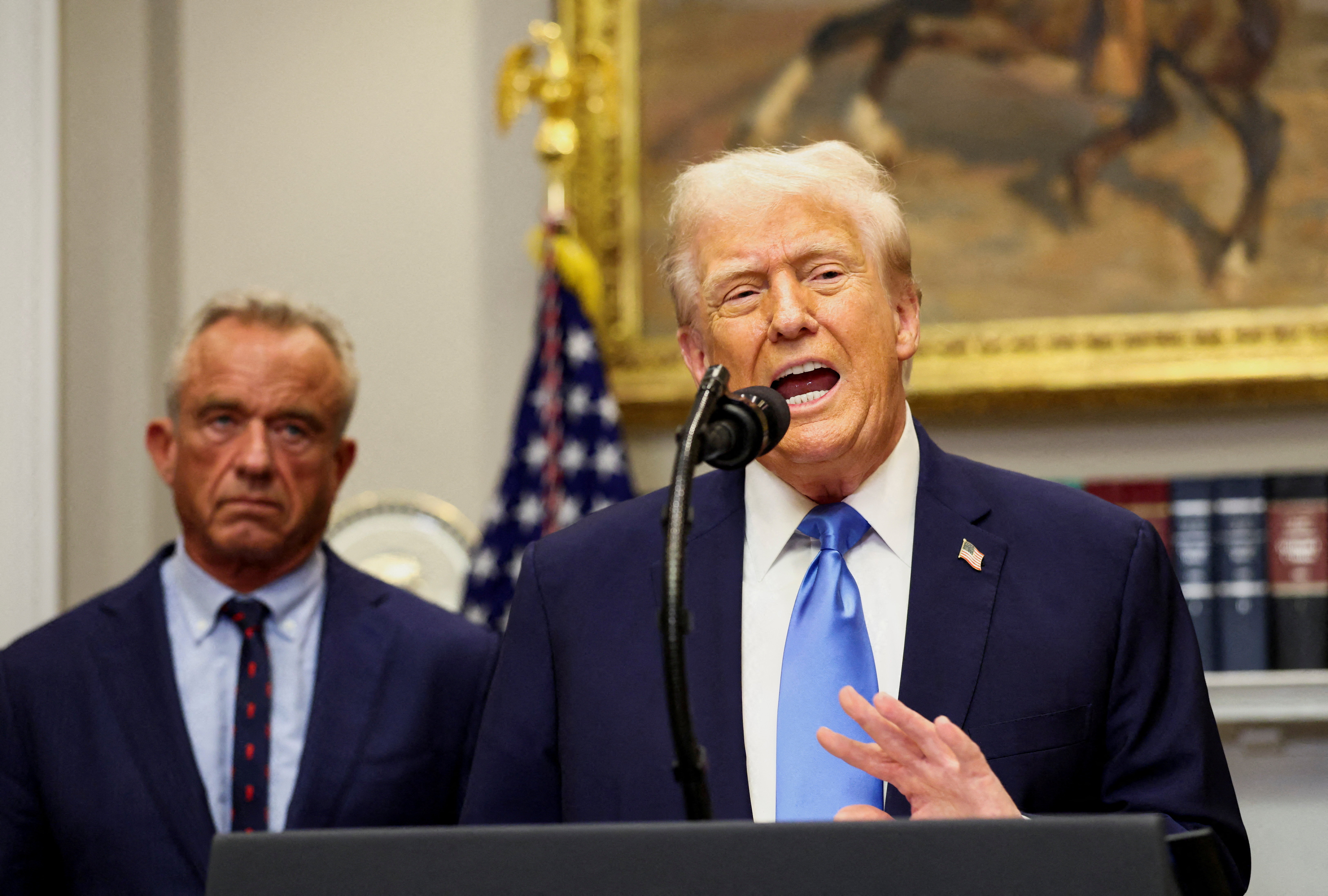 U.S. President Donald Trump, in front of U.S. Secretary of Health and Human Services Robert F. Kennedy Jr., delivers remarks linking autism to childhood vaccines and to the use of popular pain medication Tylenol for pregnant women and children, claims which are not backed by decades of science, at the White House in Washington, D.C., U.S., September 22, 2025. REUTERS/Kevin Lamarque