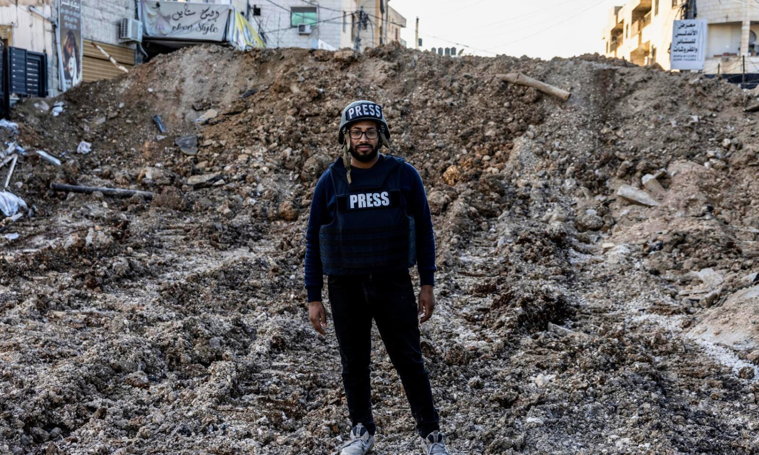 Palestinian journalist Ismail H. I. Banighorra stands on a bulldozed road in Jenin in the West Bank