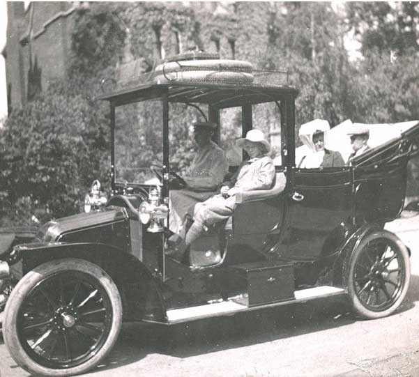 the family is seated in a 1908 Renault with the top down.