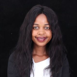 A professional photograph of a woman in front of a dark background.