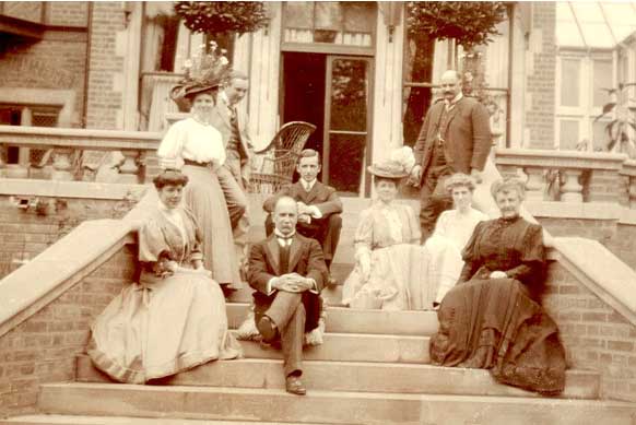 The Osler family and six guests recline on the patio steps in 1907