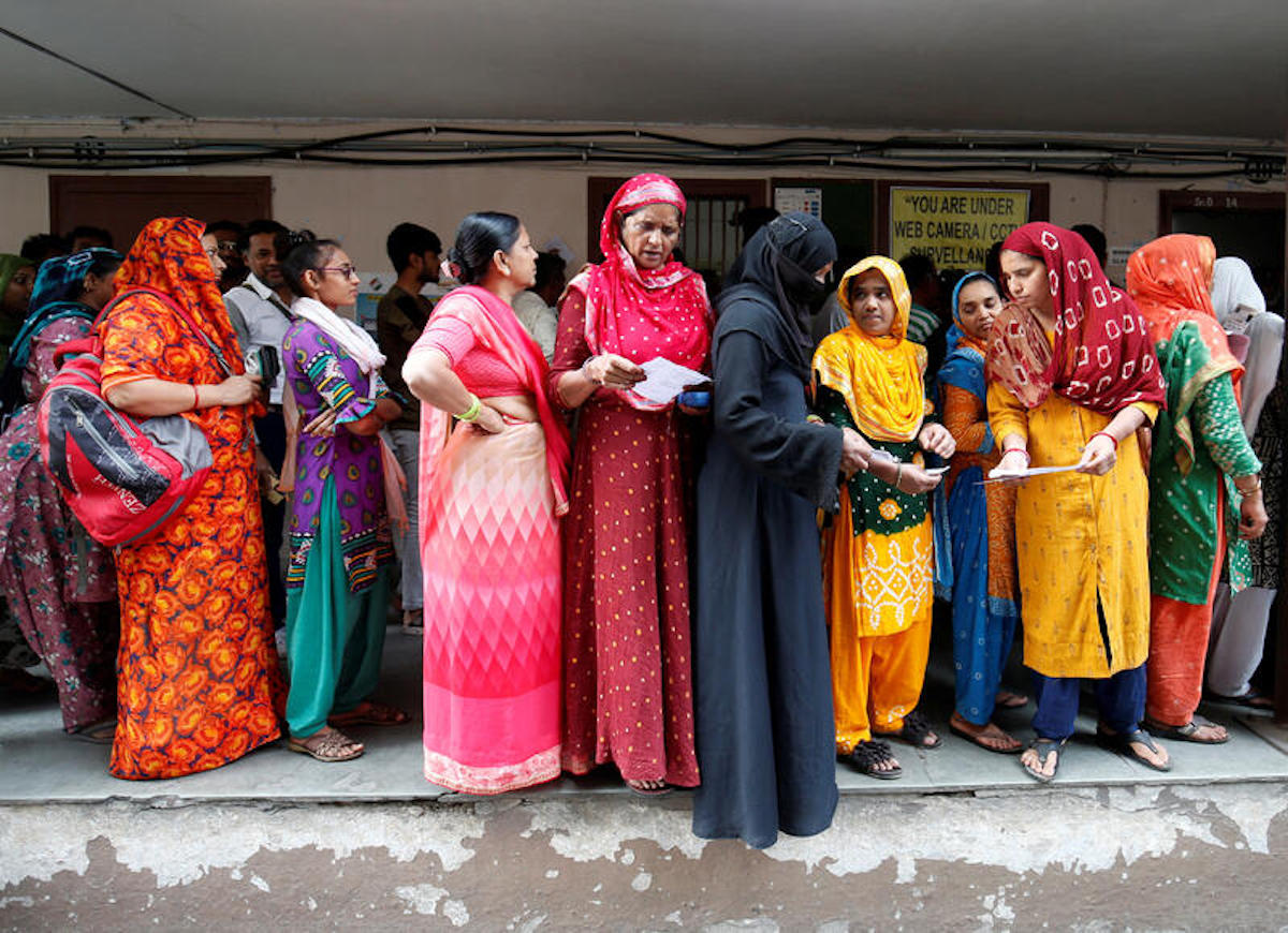 People wait in queues to cast their votes in the Gujarat state assembly election in December 2022. REUTERS/Amit Dave