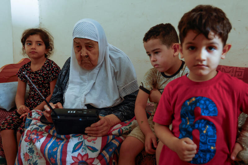 Palestinian woman Fawzeya Shaheen, 90, who lived through all Israeli-Palestinian wars dating back to 1948, sits with her grandchildren at her home, amid the ongoing Israeli-Palestinian conflict, in Khan Younis in the southern Gaza Strip October 14, 2023. 