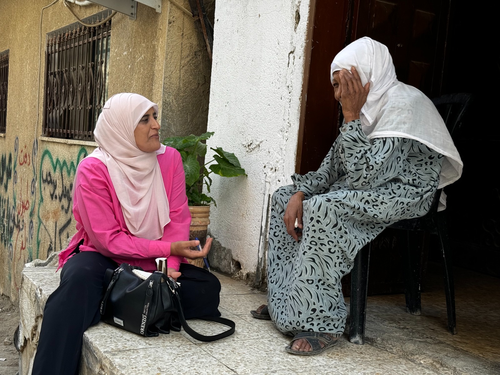 Palestinian journalist Aziza Nofal interviews an elderly resident