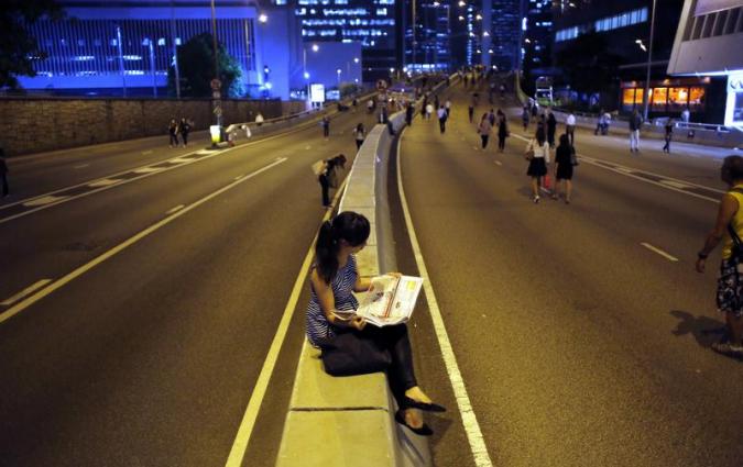 A pro-democracy protester reads a newspaper, Hong Kong. REUTERS/Carlos Barria