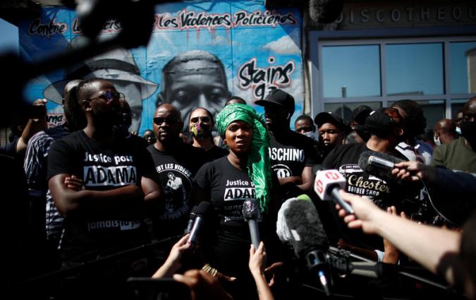 Assa Traore, sister of Adama Traore, a 24-year-old Black Frenchman who died in a 2016 police operation, talks to journalists during a gathering in front of a fresco in memory of Adama Traore and George Floyd, whose death in police custody has sparked unrest in the United States, with the slogan "against racism and police violence" painted on a wall by a group of artists "Collectif Art" in Stains, France, June 22, 2020. REUTERS/Benoit Tessier