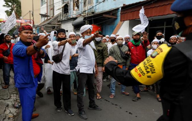 Indonesian Islamic group members argue with police officers during a protest over the detention of Rizieq Shihab, the leader of Indonesian Islamic Defenders Front (FPI), on suspicion of breaching coronavirus restrictions by staging several mass gatherings since his return from self-exile, in Jakarta, Indonesia, December 18, 2020. REUTERS/Willy Kurniawan