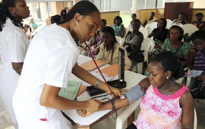 A nurse inspects a pregnant woman outside a ward at a maternity hospital renovated by Royal Dutch Shell in Obio district in Nigeria's oil city of Port Harcourt March 24, 2011. REUTERS/Akintunde Akinleye (NIGERIA - Tags: HEALTH)