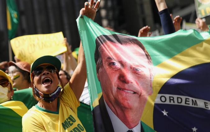 A supporter of President Jair Bolsonaro holds a banner with his image. REUTERS/Amanda Perobelli
