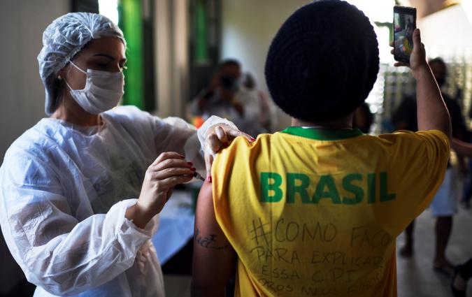 A health worker administers a dose of Johnson & Johnson vaccine against the coronavirus disease (COVID-19) to a resident as he takes a selfie, during mass vaccination at the Ilha Grande island, one of the most famous tourist spots in Rio de Janeiro state, Brazil, July 10, 2021. REUTERS/Lucas Landau