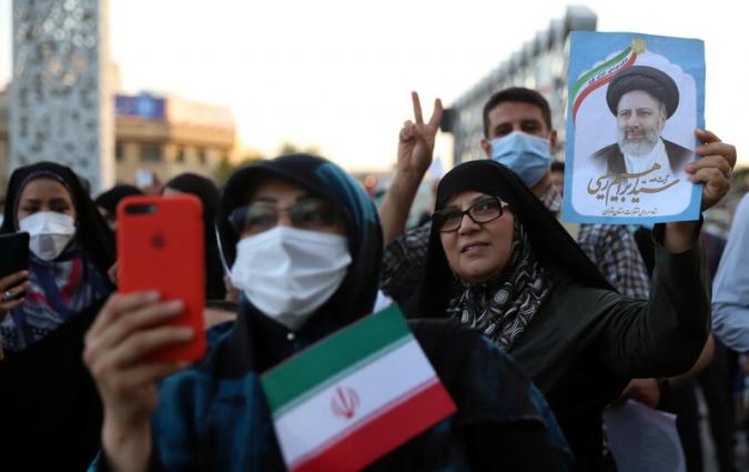 A supporter of Ebrahim Raisi holds ups his portrait during a celebratory rally for his presidential election victory in Tehran, Iran June 19, 2021. Majid Asgaripour/WANA (West Asia News Agency) via REUTERS ATTENTION EDITORS - THIS IMAGE HAS BEEN SUPPLIED BY A THIRD PARTY.